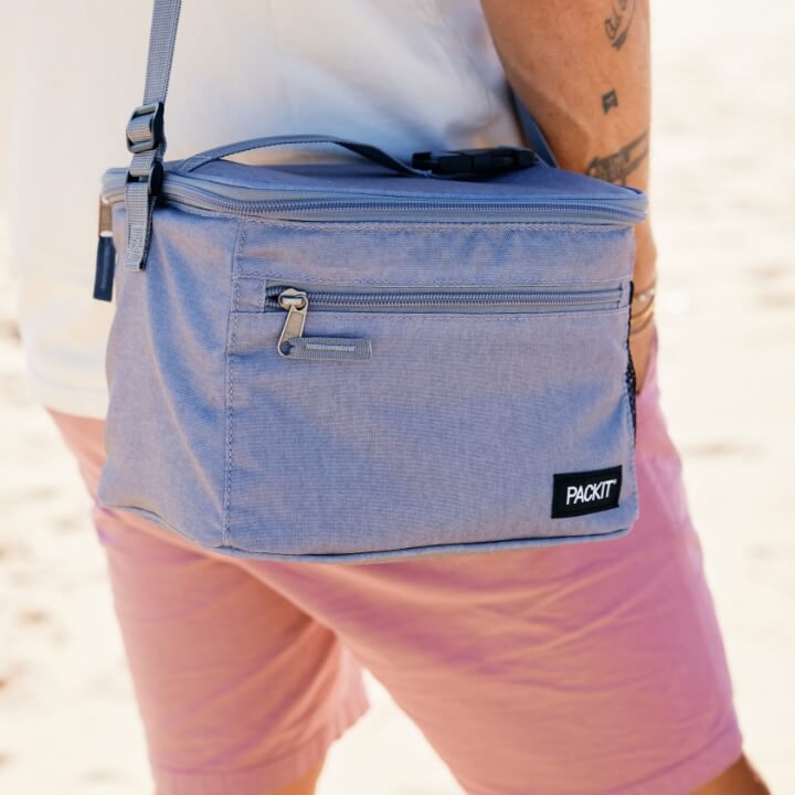 A person carrying a gray PackIt lunch cooler.